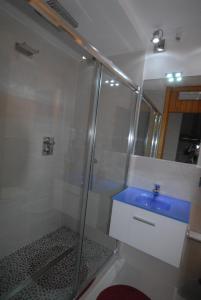ブレウイル・チェルヴィナイアにあるクロモセラピー アパートメントのバスルーム(シャワー、青いシンク付)