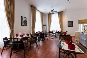 a restaurant with tables and chairs with wine glasses at Boutique Kampot Hotel in Kampot