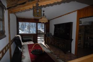 salon z żyrandolem i stołem w pokoju w obiekcie Cromotherapy Apartment w mieście Breuil-Cervinia