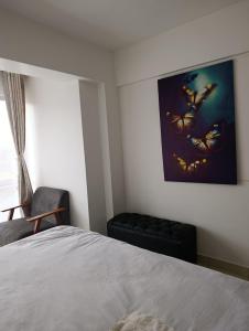 a bedroom with a bed and a picture of butterflies at Starla one bedroom duplex in Kinoo