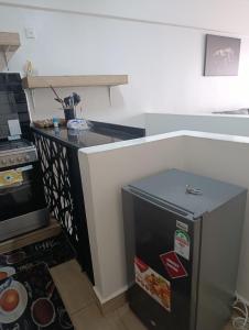 a small kitchen with a refrigerator and a stove at Starla one bedroom duplex in Kinoo +7 photos