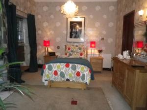 ein Schlafzimmer mit einem Bett, zwei Lampen und einem Waschbecken in der Unterkunft Bridge Hall Apartments in Weston-super-Mare
