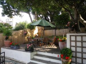 eine Terrasse mit einem Tisch, Stühlen und einem Sonnenschirm in der Unterkunft Bridge Hall Apartments in Weston-super-Mare