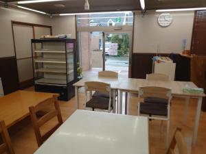 a room with a table and chairs and a clock at 民宿たけだ家 in Saka +7 photos