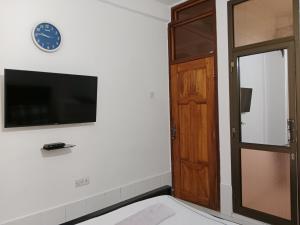 a room with a door and a clock on the wall at Hidalgo Home Apartment's in Moshi