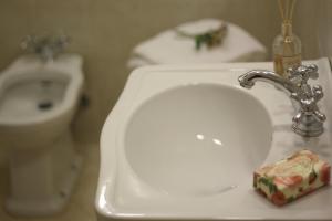 um lavatório de casa de banho com um dispensador de sabão ao lado de um WC em Residenza Millennium em Florença