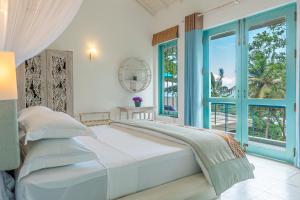 a white bedroom with a large bed and a window at Monara - Tangalle in Tangalle
