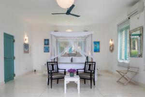 a bedroom with a bed and two chairs and a table at Monara - Tangalle in Tangalle