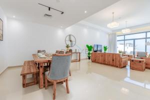 a living room with a wooden table and chairs at Elegant 4BR Villa with Arabian Gulf, Mountain and Community Views, Assistant Room and Heated Pool, Al Dana Island, Fujairah by Deluxe Holiday Homes in Fujairah