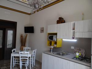cocina con fregadero y mesa con sillas en Casa Vacanze Giani, en Terrasini