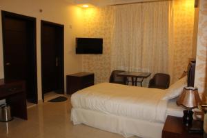 a hotel room with a bed and a table and a television at Dar Al Khaleej Hotel Apartments in Al Buraymī