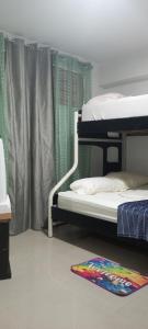 a bedroom with two bunk beds and a rug on the floor at Apartamento Playero cerca del Aeropuerto de Maiquetía in Catia La Mar
