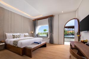 a bedroom with a large bed and a large window at La Tropica Canggu Bali By Kanaya Hospitality in Canggu