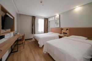 a hotel room with two beds and a flat screen tv at GreenTree Inn Anqing Renmin Road Commercial Street Express Hotel in Anqing +228 photos