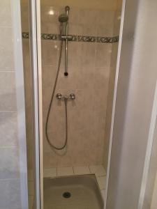 a shower with a hose in a bathroom at Chambres d'hôtes du puy d'anché in Sauzé-Vaussais