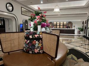 ソウルにあるDexter Hotelの椅子2脚と花が飾られたテーブルのあるロビー