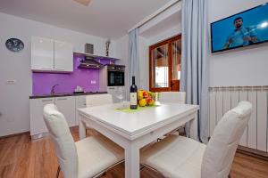 una cucina con un tavolo bianco e sedie bianche di Apartment Api a Rovigno (Rovinj) Altre 8 foto