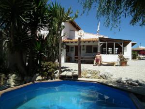 a man sitting in front of a house at Da Silva Surfcamp in Areia Branca