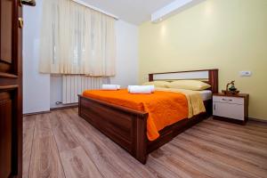 una camera da letto con un letto grande con una coperta arancione di Apartment Api a Rovigno (Rovinj)