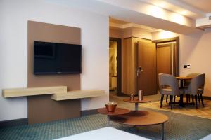 a hotel room with a television and a table with chairs at Tophane Suites in Istanbul