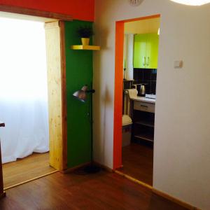 a kitchen with green and orange walls and a lamp at Nexus Happy in Miercurea-Ciuc