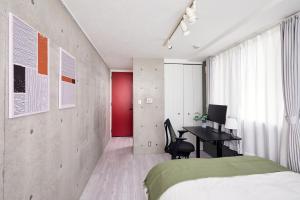 a bedroom with a bed and a desk with a computer at Shirogane Apartment in Tokyo