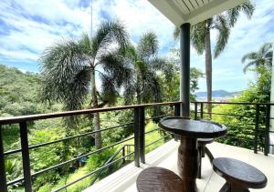 Un balcón con una mesa y dos sillas y una vista. en Quiet Seaview House 1 Bedroom Patong, en Patong Beach
