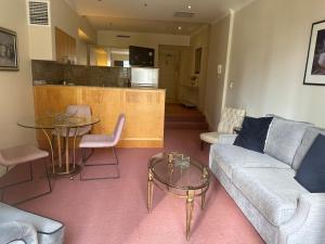 a living room with a couch and a table at Central Apartment BON21409 in Sydney