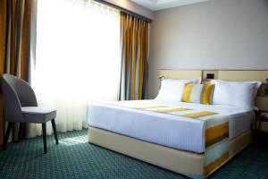 a bedroom with a bed and a chair and a window at Tophane Suites in Istanbul