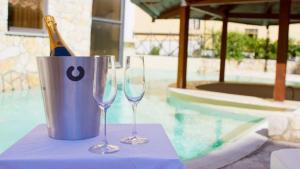 two wine glasses on a table next to a pool at The Strand Hotel in Rome