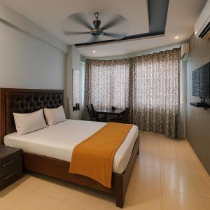 a bedroom with a bed and a table in it at Hotel Sai Samrat INN in Navi Mumbai