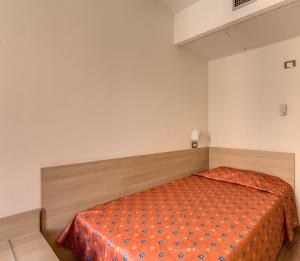 a bedroom with a bed with an orange bedspread at Hotel San Remo in Rome