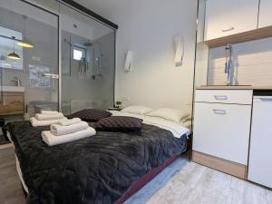 a bedroom with a large bed with towels on it at Cowshed w Floor Heating in Ugly Duckling Courtyard in Zagreb