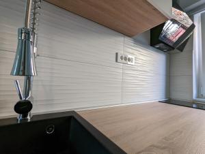 a kitchen with a wall with a table and a lamp at Cowshed w Floor Heating in Ugly Duckling Courtyard in Zagreb