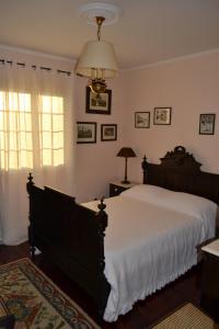 a bedroom with a large bed and a chandelier at C&C Home in Ponta Delgada
