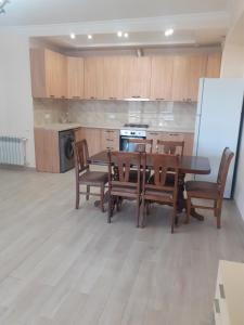 une cuisine avec une table, des chaises et un réfrigérateur dans l'établissement Дом в центре города, à Erevan