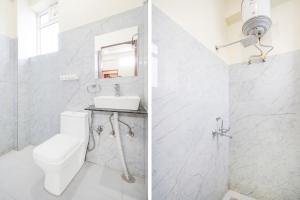 DahmiにあるHotel O Radha Residencyのトイレと洗面台を備えた白いバスルーム
