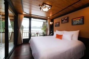 Un dormitorio con una cama grande y una ventana grande. en Victory Boutique Cruise, en Ha Long