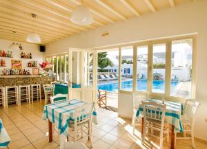 Villa mit einem Pool, einem Tisch und Stühlen in der Unterkunft Anemos Hotel & Apartments in Ornos