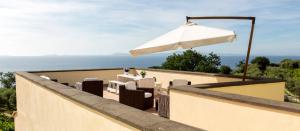 a patio with an umbrella and a table and chairs at Relais Regina Giovanna in Sorrento