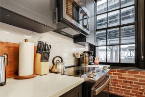 a kitchen with a stove top oven next to a window at Roami at The Lola Convention Center 1BR #14 in New Orleans