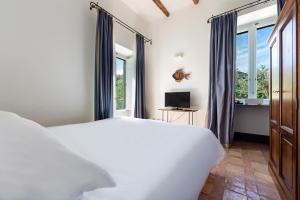 a bedroom with a large white bed and windows at Relais Regina Giovanna in Sorrento