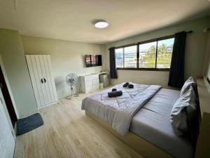 バン　メー　ナムにあるThe Nest Mae nam - Bophutのベッドルーム1室(ファン、窓付)