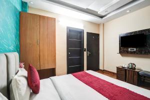 a bedroom with a bed and a flat screen tv at Hotel Twamev Couple Friendly Laxmi Nagar in New Delhi