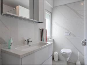 a white bathroom with a sink and a toilet at Villa in Vrsi with Pool near Sandy Beach in Vrsi +21 photos