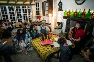un grupo de personas sentadas alrededor de una mesa en una habitación en Da Silva Surfcamp en Areia Branca