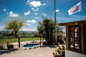 a house with a swimming pool and a flag at Da Silva Surfcamp in Areia Branca