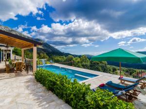 ein Swimmingpool mit Blick auf einen Berg in der Unterkunft Villa Falcon Rook - Four-Bedroom Villa with Terrace and Swimming Pool in Dubravka