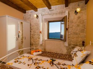 ein Schlafzimmer mit einem Bett und einem Fenster in der Unterkunft Villa Falcon Rook - Four-Bedroom Villa with Terrace and Swimming Pool in Dubravka + 55 Fotos