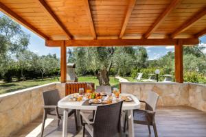 a patio with a table and chairs under a wooden pergola at Detached villa with 2 bathrooms in Lupetto